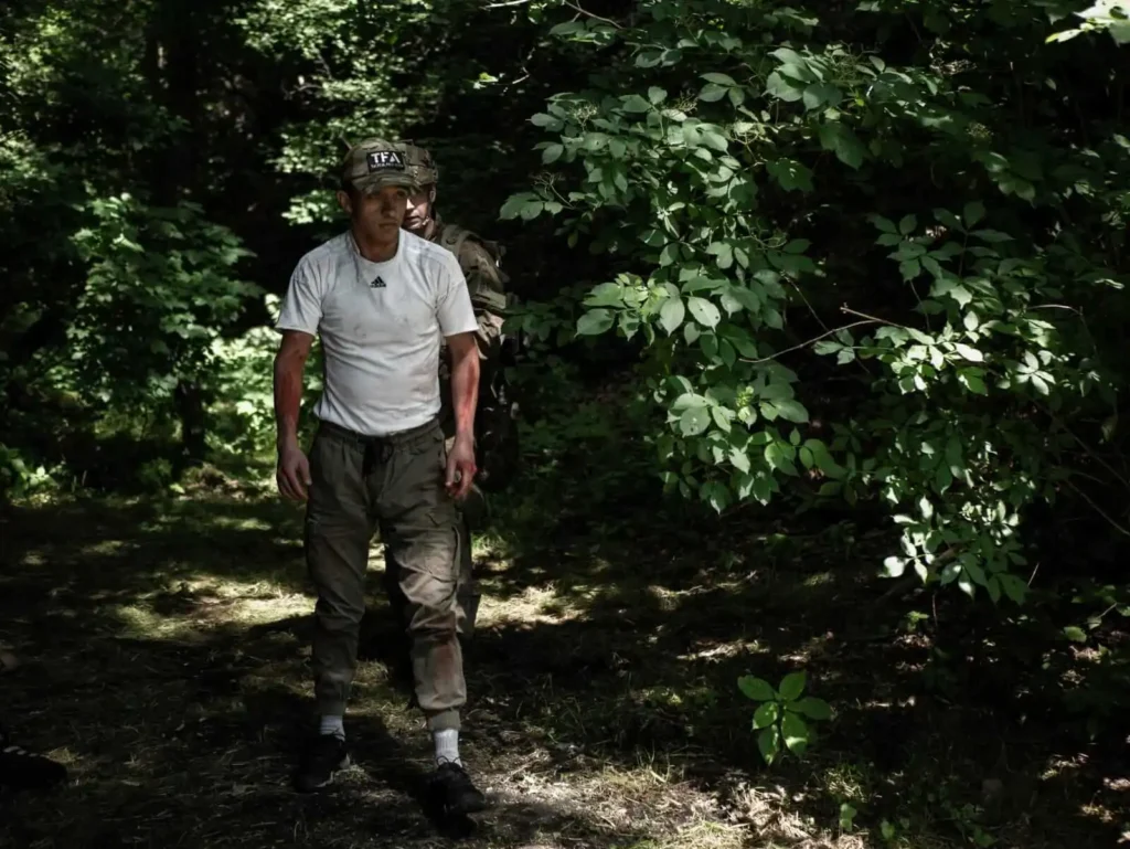 Uczestnik symulacji medycznej poruszający się w terenie leśnym