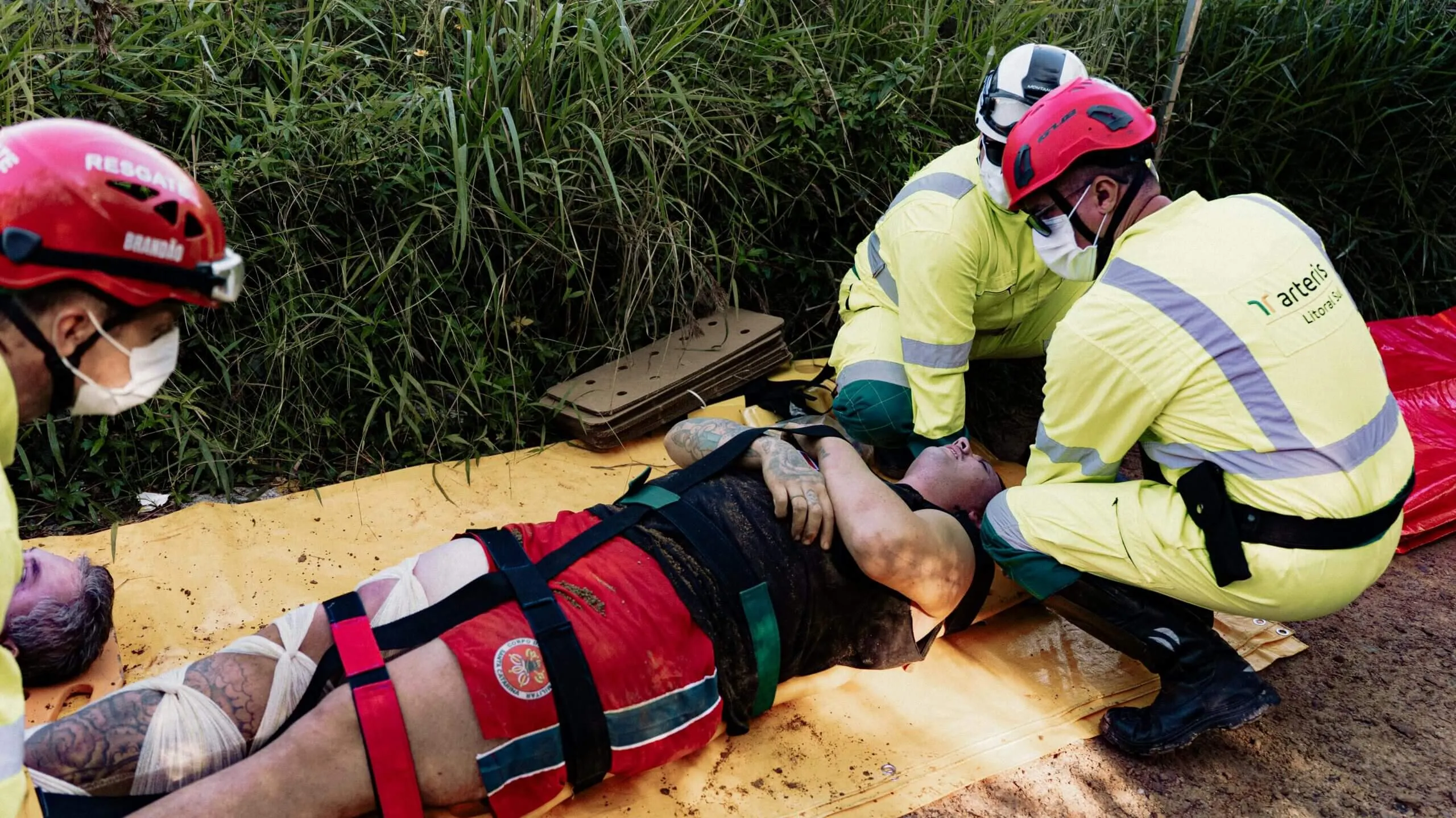 Ratownicy stabilizujący poszkodowanego na noszach podczas akcji w terenie