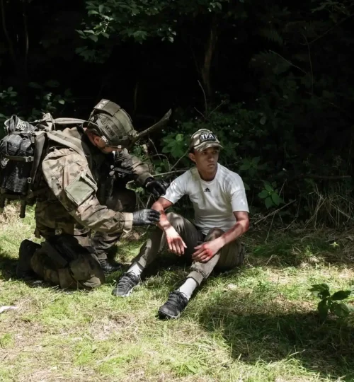Ratownik udzielający pomocy w terenie leśnym podczas szkolenia medycznego